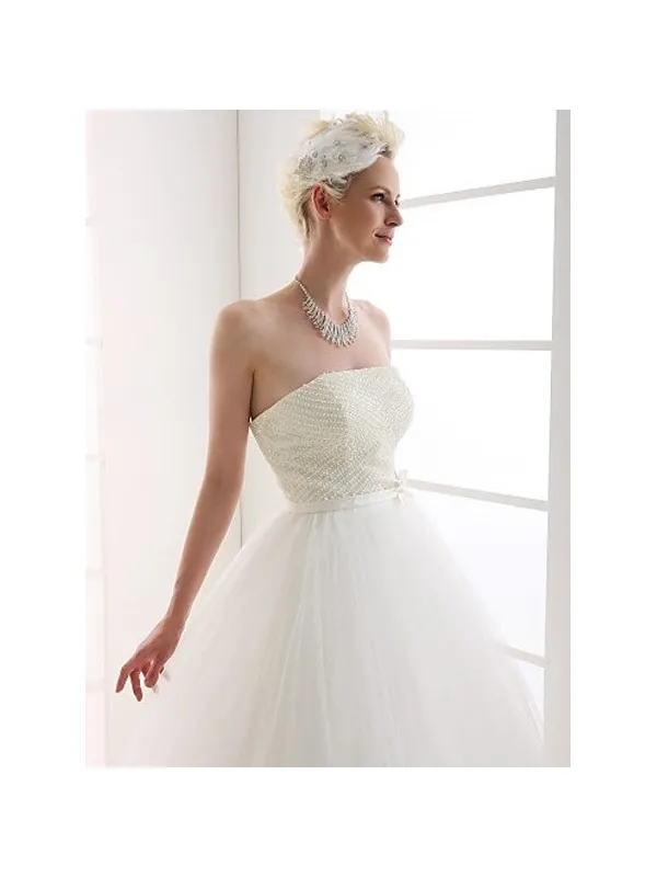 Abito da sposa minimal con corpetto pieno di perline e gonna morbida in tulle